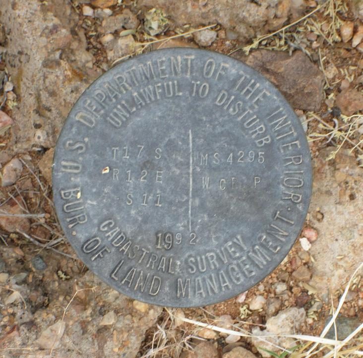 A brass Bureau of Land Management cadastral survey cap stamped with section numbers